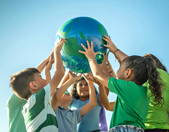 Kinderen die een wereldbol omhoog houden